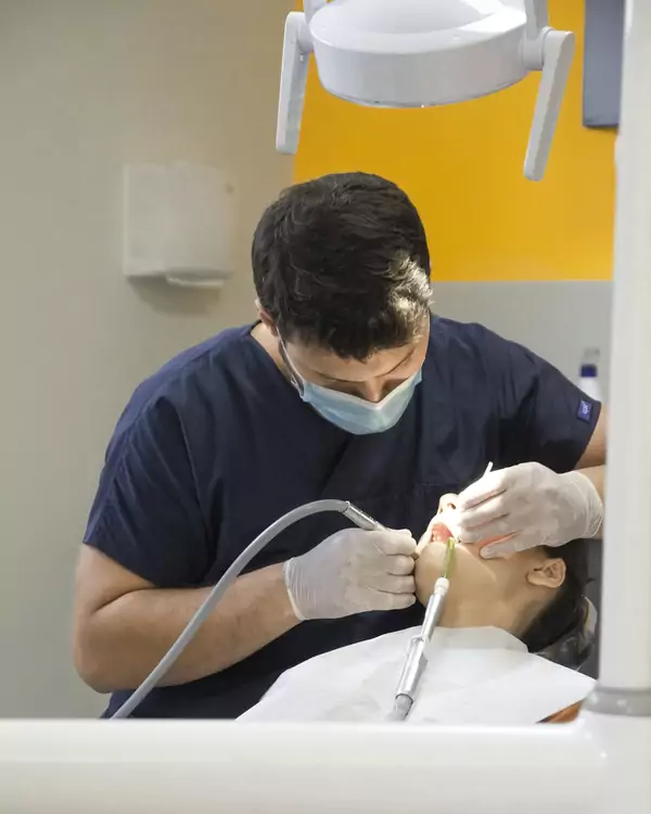 Dentista haciendo una limpieza dental a un paciente
